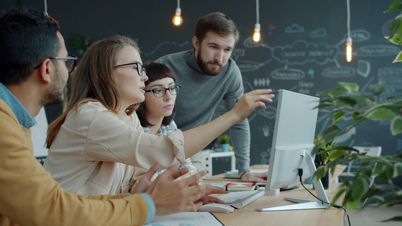 A team collaborating around a shared screen